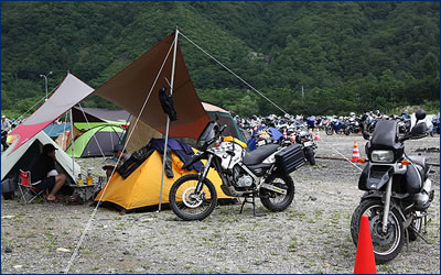 駐車スペースの隣には広いキャンプサイトが用意されている。バイクを乗り入れ、そのすぐ横にテントを張る。もっとも会場に近い宿泊地だ。