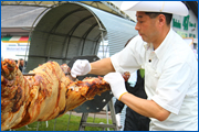 その豚を繊細かつダイナミックに切り刻む料理人。ひと口サイズに整えられ、毎年来場者に無料で提供しています。１頭でだいたい200人分です。